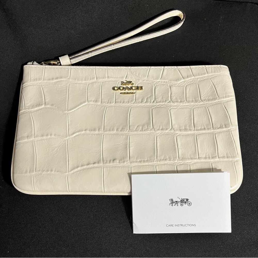 COACH wristlet; 8”x5”; cream color with gold embellishment